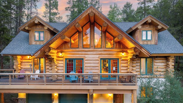 A log cabin with a balcony, large windows, and a garage. - Mountain View Log Home I Hot Tub I Arcades I Great Views I Sauna I Discounted Attractions (Fraser)