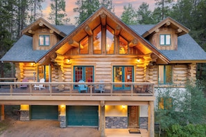 A log cabin with a balcony, large windows, and a garage. - Mountain View Log Home I Hot Tub I Arcades I Great Views I Sauna I Discounted Attractions (Fraser)