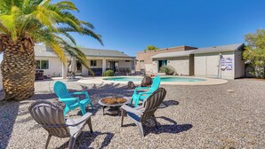 A courtyard with outdoor seating, a pool, and a palm tree. - Lake Havasu Getaway w/ Pool, Hot Tub & Game Room (Lake Havasu City)