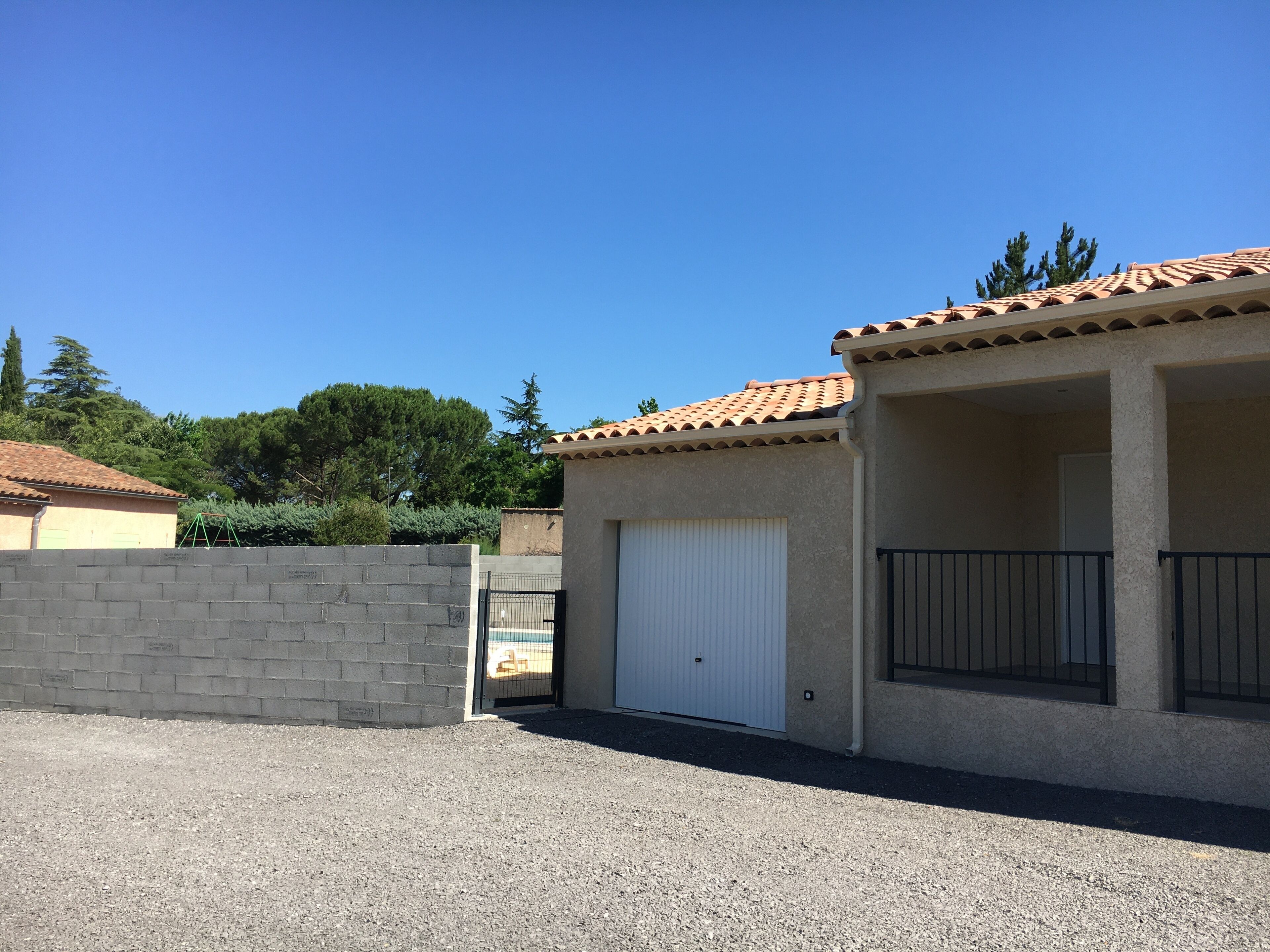 Un edificio con tetto in tegole, ingresso sorvegliato e vialetto sterrato.