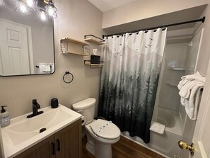 A bathroom with a toilet, sink, and shower curtain. - Relax and feel at home in this completely renovated vacation condo at the Nordic (Lincoln)