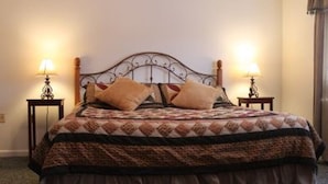 A bed with a patterned bedspread and two pillows, flanked by two bedside tables with lamps. - Great vacation condo w/views of the mountains  #214 (Lincoln)