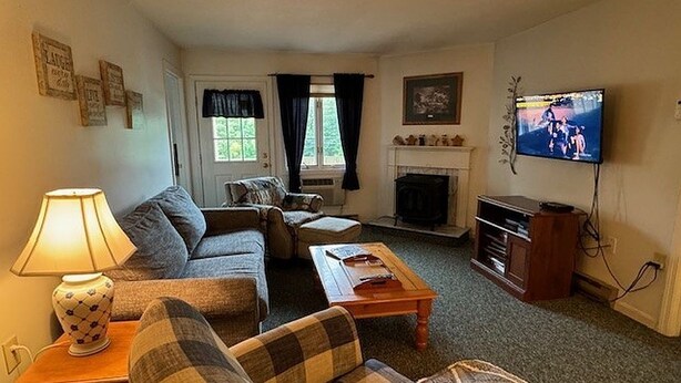 A cozy living room with a sofa, a coffee table, a fireplace, and a television. - Great vacation condo w/views of the mountains  #214 (Lincoln)
