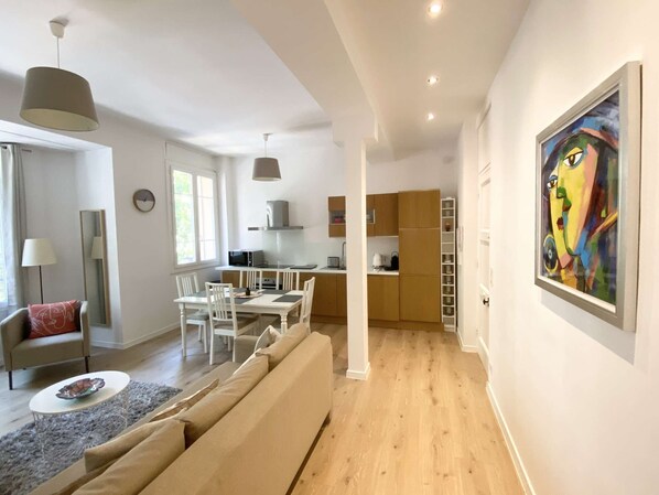 Um apartamento moderno com sala de estar, sala de jantar e cozinha.