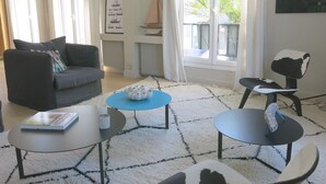 A modern living room with a grey sofa, a blue coffee table, and a white rug. - Sacré Coeur CityCosy (Paris)