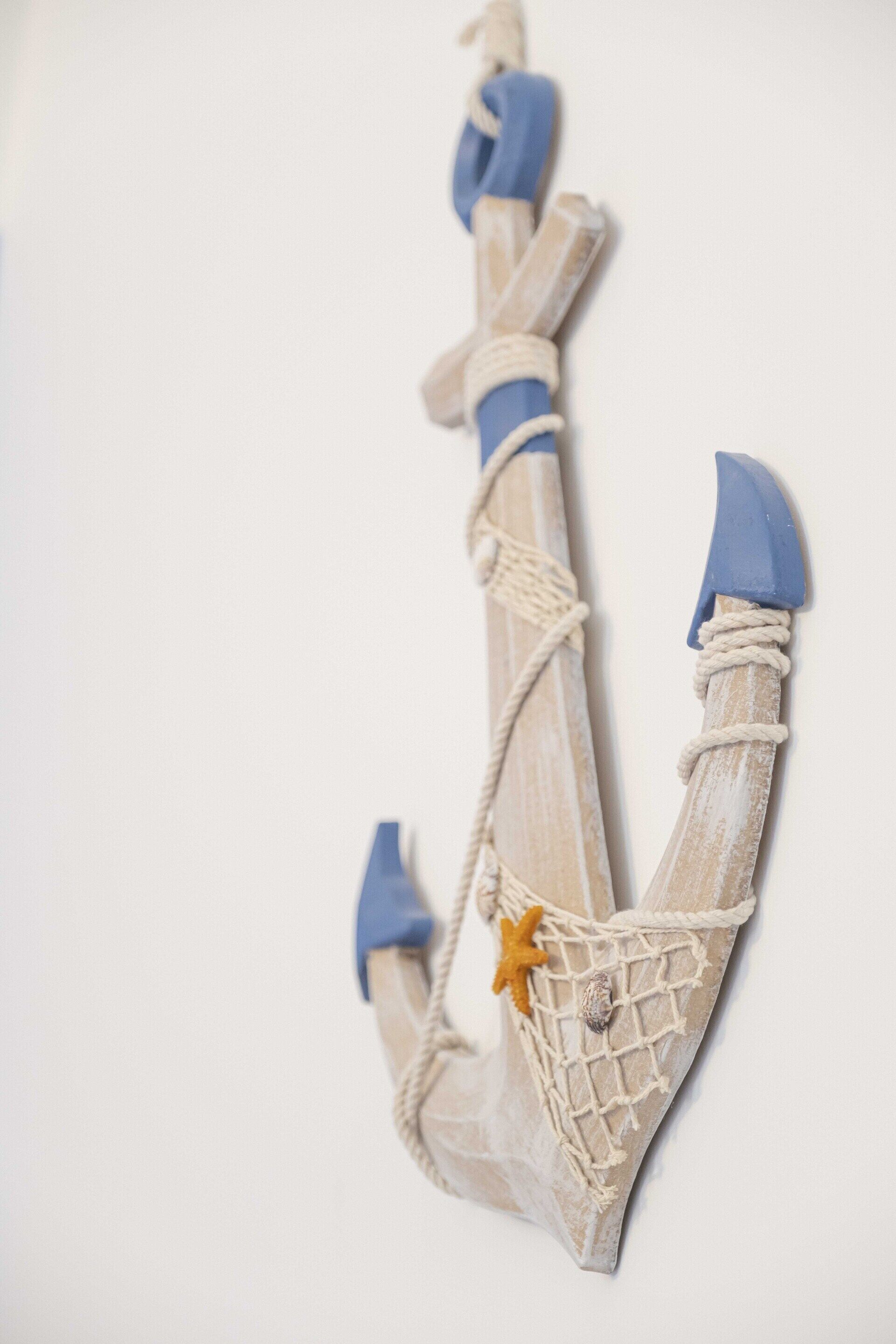 A wooden anchor with rope and starfish decoration.