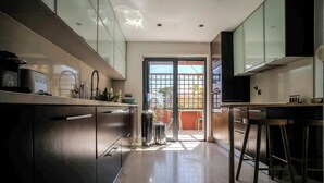 A modern kitchen with stainless steel appliances, a large window, and a view of the outdoors.