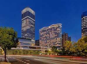 A modern hotel with a curved facade, multiple floors, and a prominent signage. - Shangri-La Qiantan, Shanghai (Shanghai)