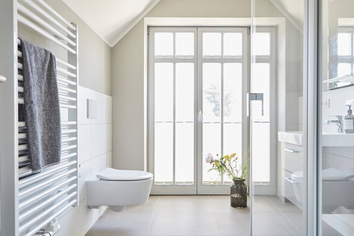A modern bathroom with a toilet, a glass shower enclosure, and a sink.