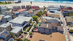 A coastal residential area with a beach view, houses with varied architecture, and a clear sky. - Steps to Ocean + Bright Top Level Unit + Sun Deck (San Diego)