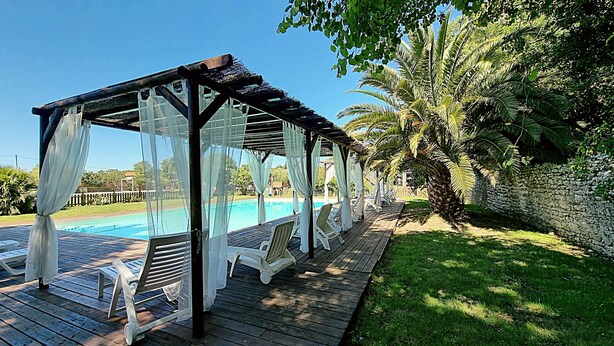 A wooden deck with a pool, white chairs, and a pergola with sheer curtains. - The Plough House with 4 bedrooms (Saint-Just-Luzac)