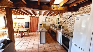 Una cocina compacta con una isla central, lavavajillas integrado, estufa y refrigerador.