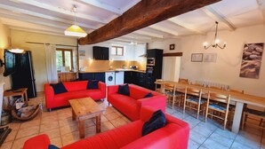 Ein Wohnzimmer mit roten Sofas, einem Holztisch und einem Essbereich mit einem Holztisch und Stühlen.