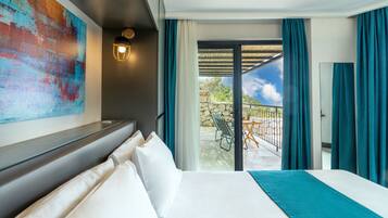 Una habitación de hotel con una cama grande, vista del patio exterior y un cuadro abstracto colorido en la pared.