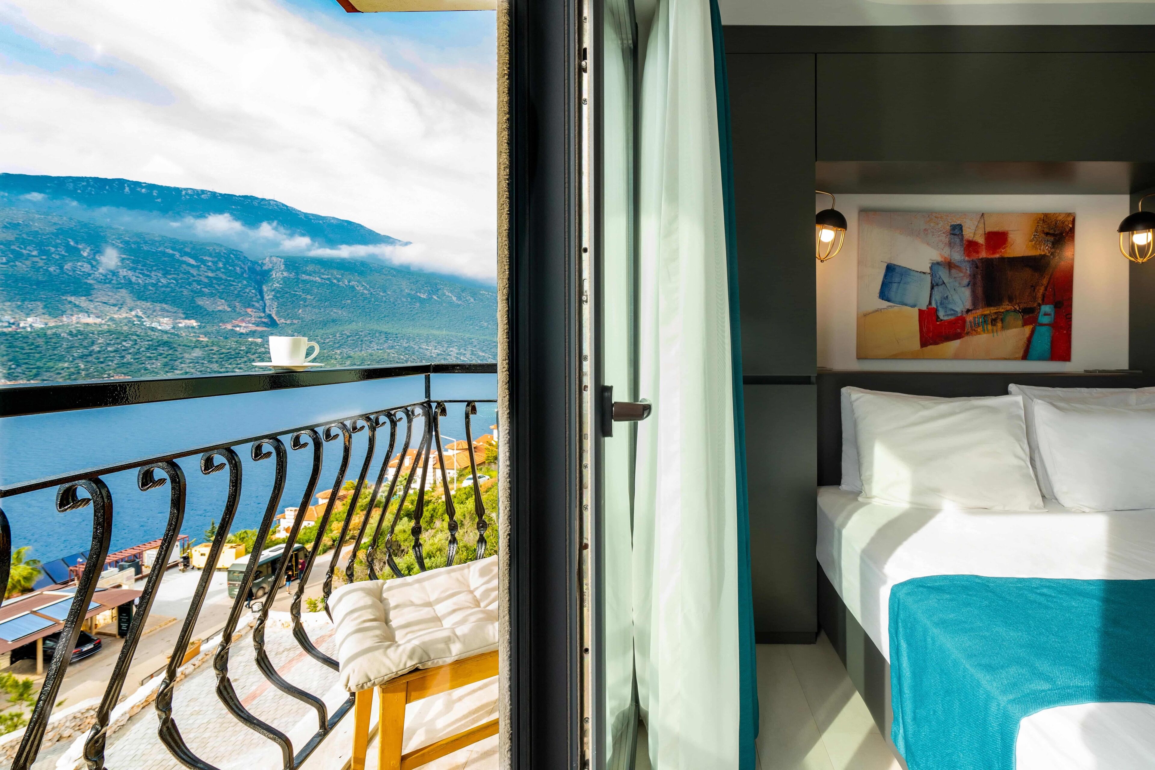 A balcony with a view of a mountainous landscape and a body of water.