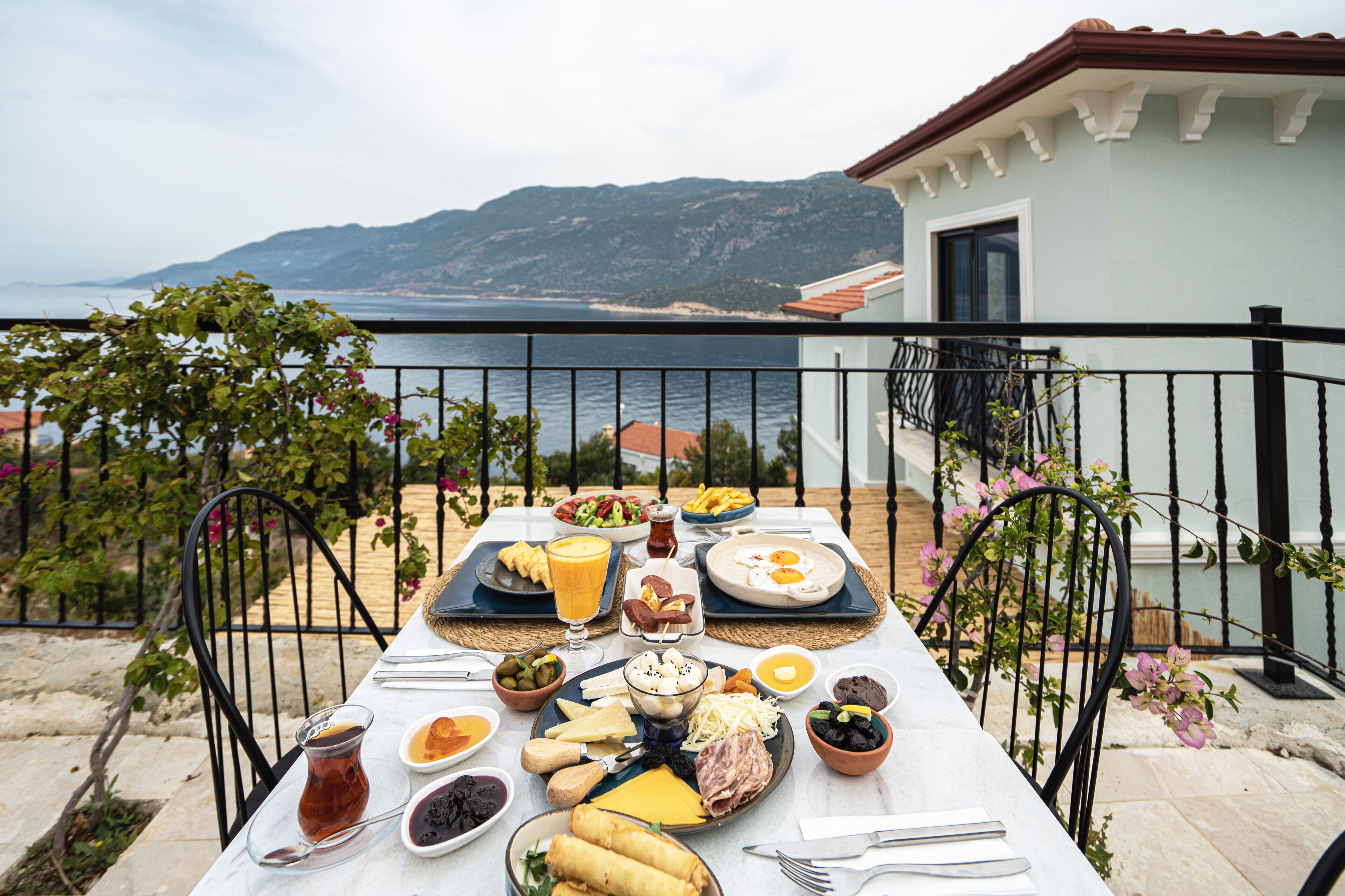 Una mesa dispuesta para el desayuno con vistas al mar y a las montañas.