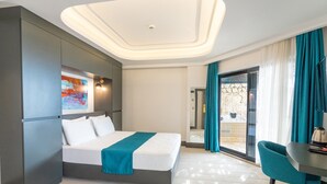 A modern hotel room with a bed, a desk, and a view of the outside. - GÜMÜŞ YAZAR  HOTEL (Kas)
