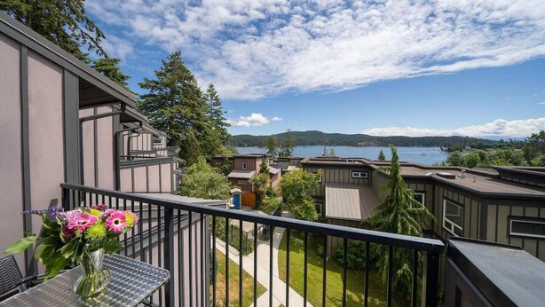 A balcony with a view of a lake and surrounding buildings.