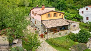 A two-story house with a stone foundation, a tiled roof, and a small attached structure with a porch. - Casa Mira - Two Bedroom Holiday Home with Pool (Pazin)
