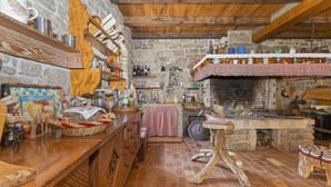 A rustic kitchen with stone walls, wooden beams, and a brick floor. - Casa Mira - Two Bedroom Holiday Home with Pool (Pazin)