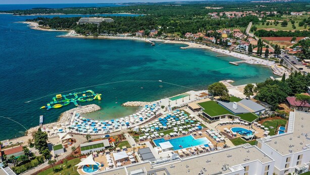 An aerial view of a coastal resort with a large swimming pool, beach areas, and a marina. - Apartment Nola - Two Bedroom Apartment with Balcony (Porec)