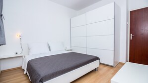 Una camera da letto con un letto, un armadio, un comodino e una scrivania.