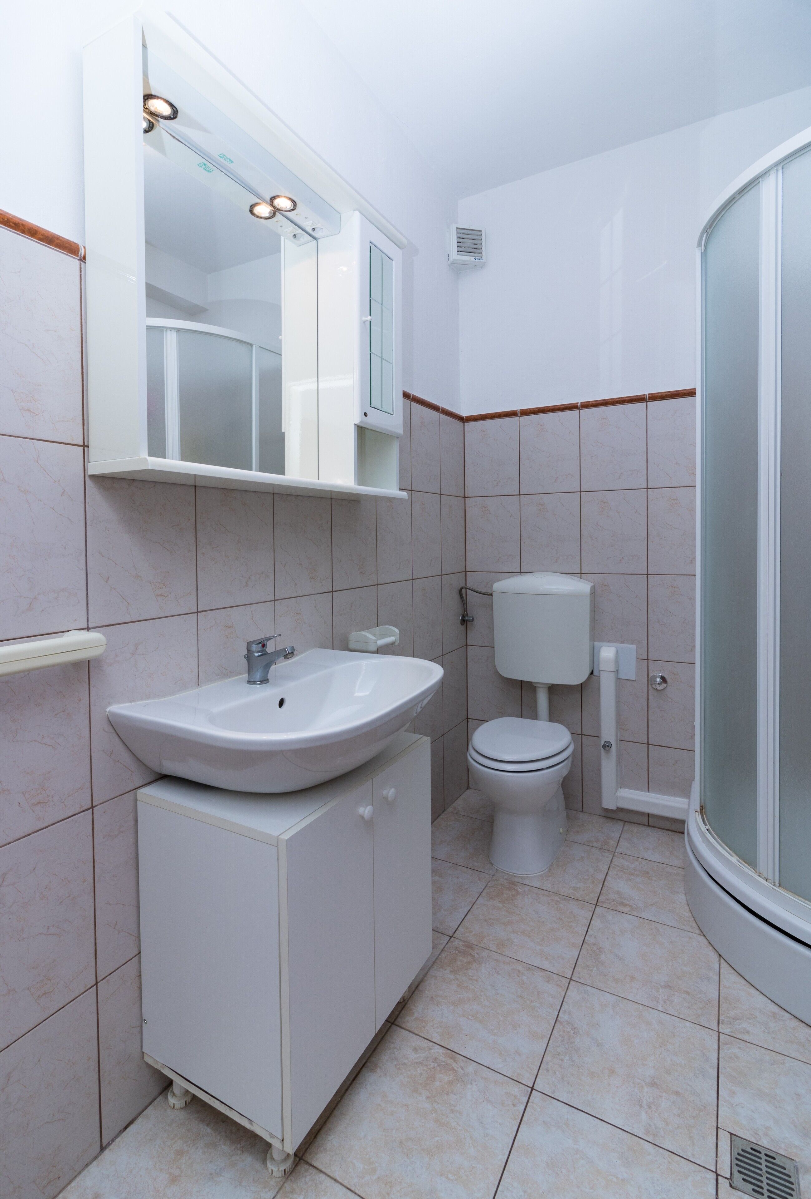 A bathroom with a sink, toilet, and shower.