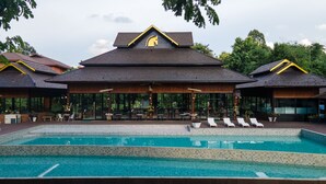 A resort with a swimming pool, outdoor seating, and a restaurant. - Phumontra Resort Nakhon Nayok (Nakhon Nayok)