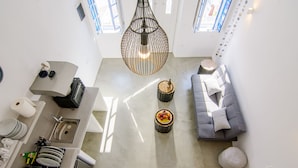 A modern kitchen with a sink, countertop, and a hanging light fixture. - ArcadOia (Santorini)