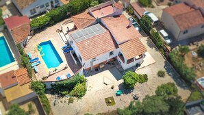 An aerial view of a residential property with a swimming pool, solar panels, and a garden area. - Villa near the beach with private pool (Calpe)