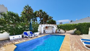 A swimming pool with lounge chairs, a patio area, and a small outdoor kitchen. - Villa near the beach with private pool (Calpe)