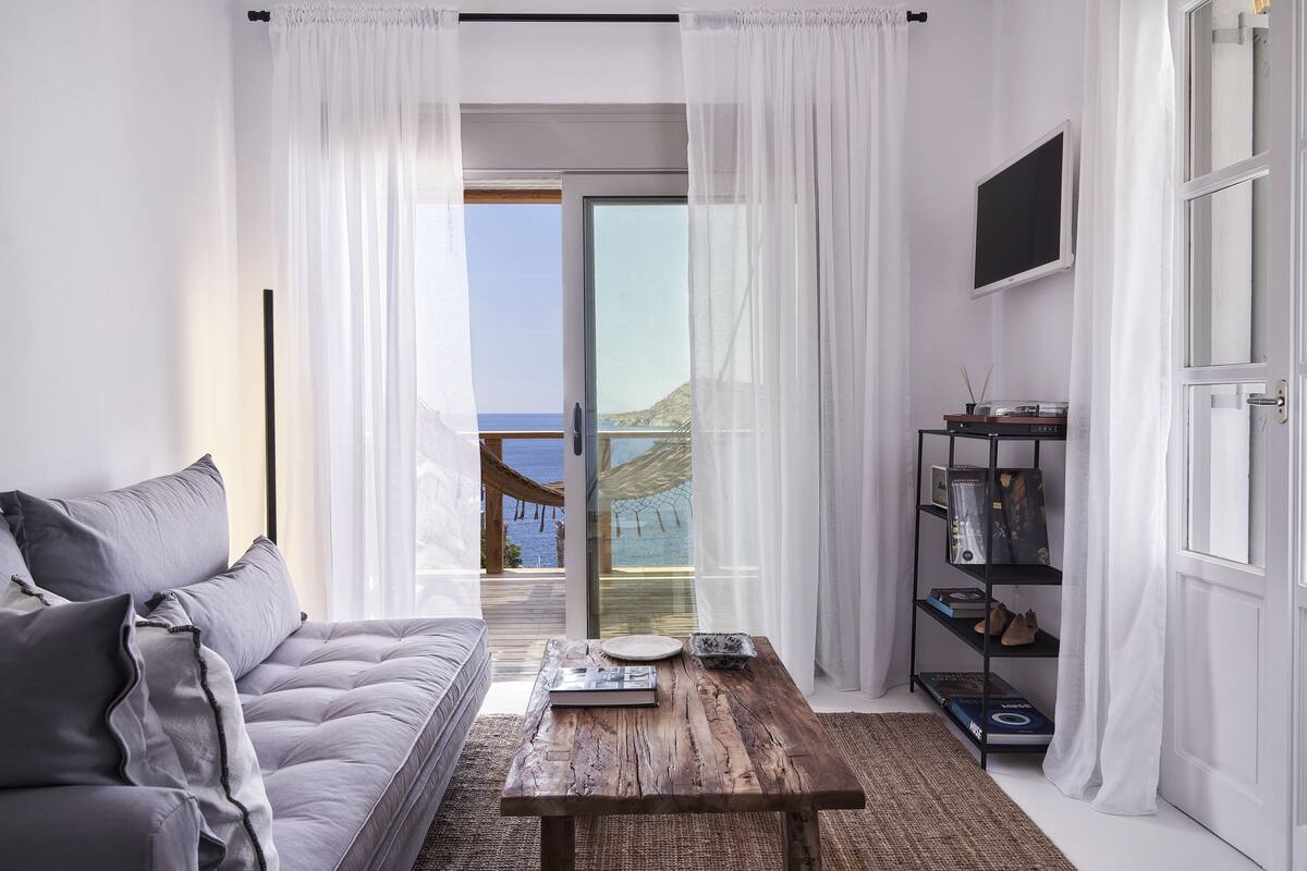 A modern bedroom with a sofa, a wooden coffee table, and a bookshelf.