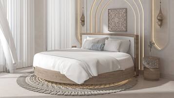 A bedroom with a round bed, a view of the city, and a decorative wall piece.