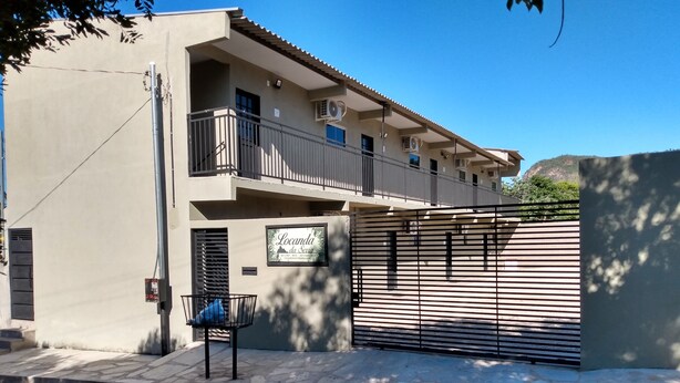 Un immeuble de deux étages doté d’un balcon et d’une entrée fermée par un portail.