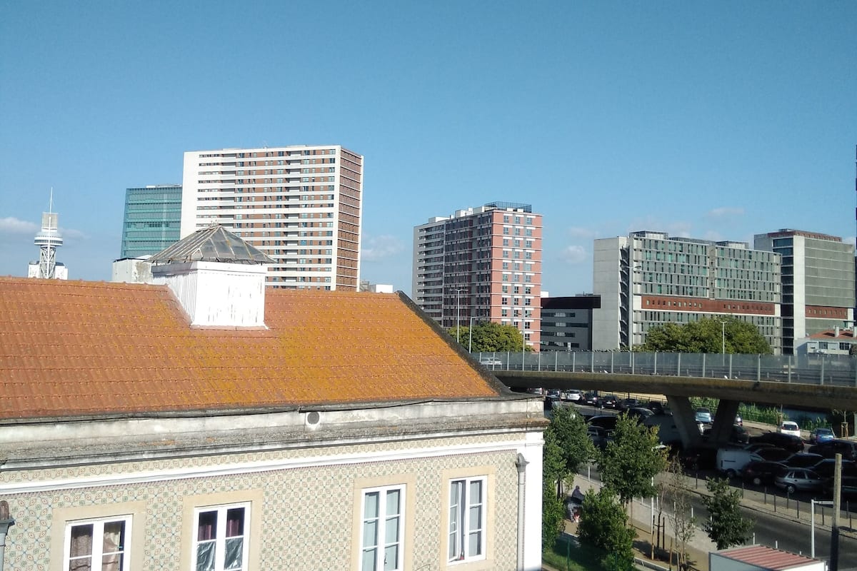 A cityscape with a mix of modern and traditional buildings, a bridge, and a road with vehicles.