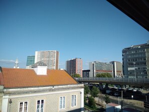 A cityscape with modern buildings, a pedestrian bridge, and a historic building with patterned walls.