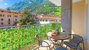 Un balcon avec une table, des chaises et une vue sur une montagne.