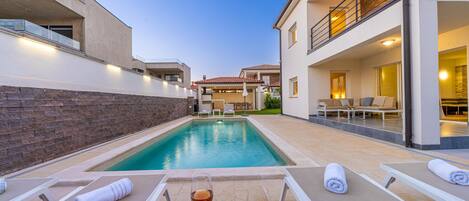 Una piscina al aire libre, una piscina climatizada