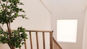 A staircase with wooden railings and a potted plant on the left. - Superior Beach Apartments Marina di Ragusa (Marina di Ragusa)