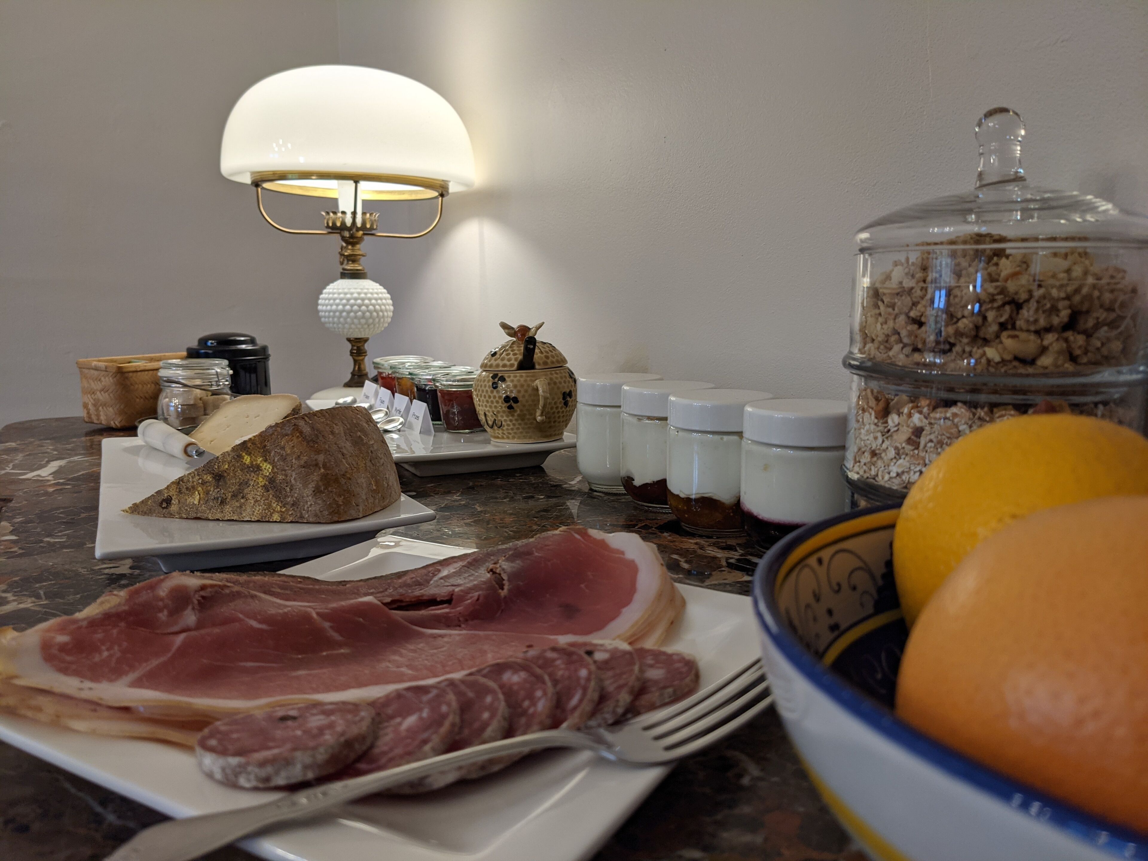 Een ontbijttafel met diverse etenswaren, een lamp en toevoegingen.