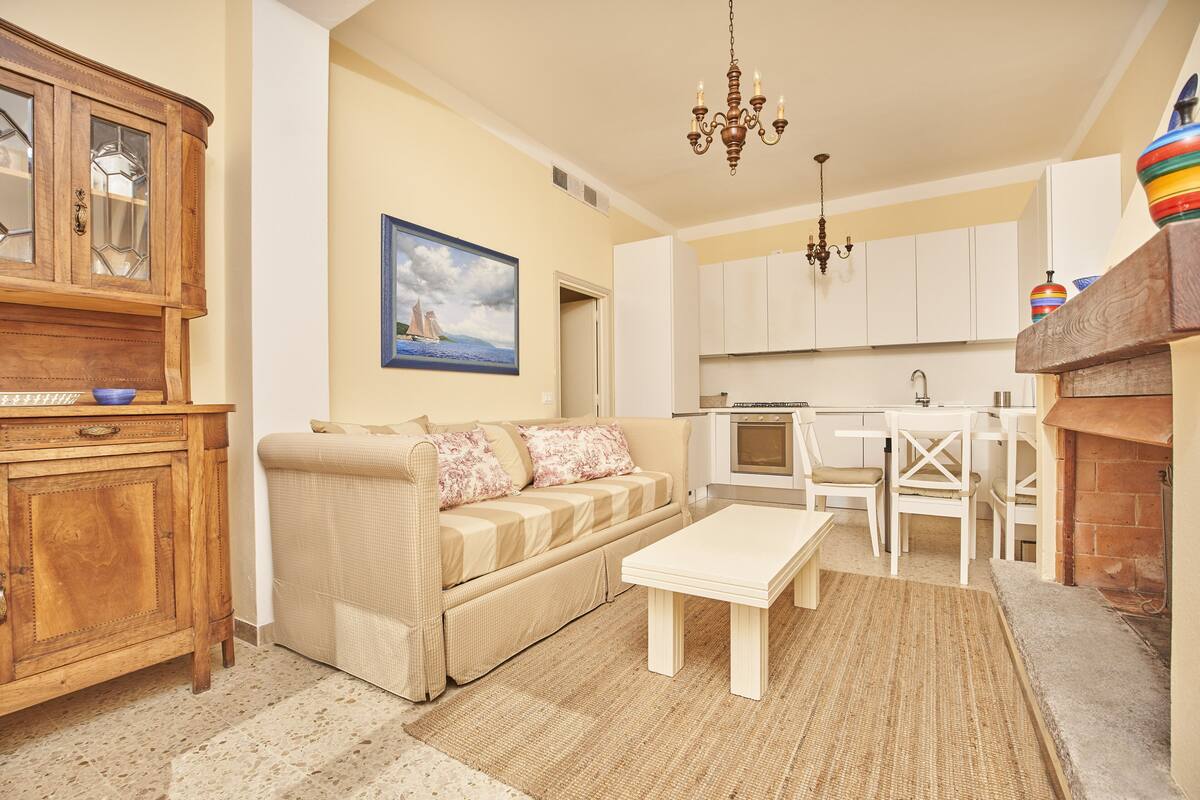 A living room with a sofa, coffee table, wooden cabinet, and a painting on the wall.