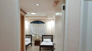 A corridor with two beds, a ceiling fan, and a door labeled "JARD". - OYO 799 Ddd Habitat Iloilo (Iloilo)
