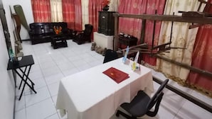 A room with a dining table, chairs, a sofa set, and curtains. - OYO 799 Ddd Habitat Iloilo (Iloilo)