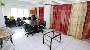 A conference room with a large table, multiple chairs, and a whiteboard. - OYO 799 Ddd Habitat Iloilo (Iloilo)