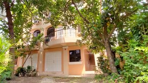 A multi-story building with a balcony, surrounded by lush greenery. - OYO 799 Ddd Habitat Iloilo (Iloilo)