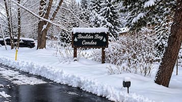 A snowy landscape with a sign for Boulder Bay Condos.