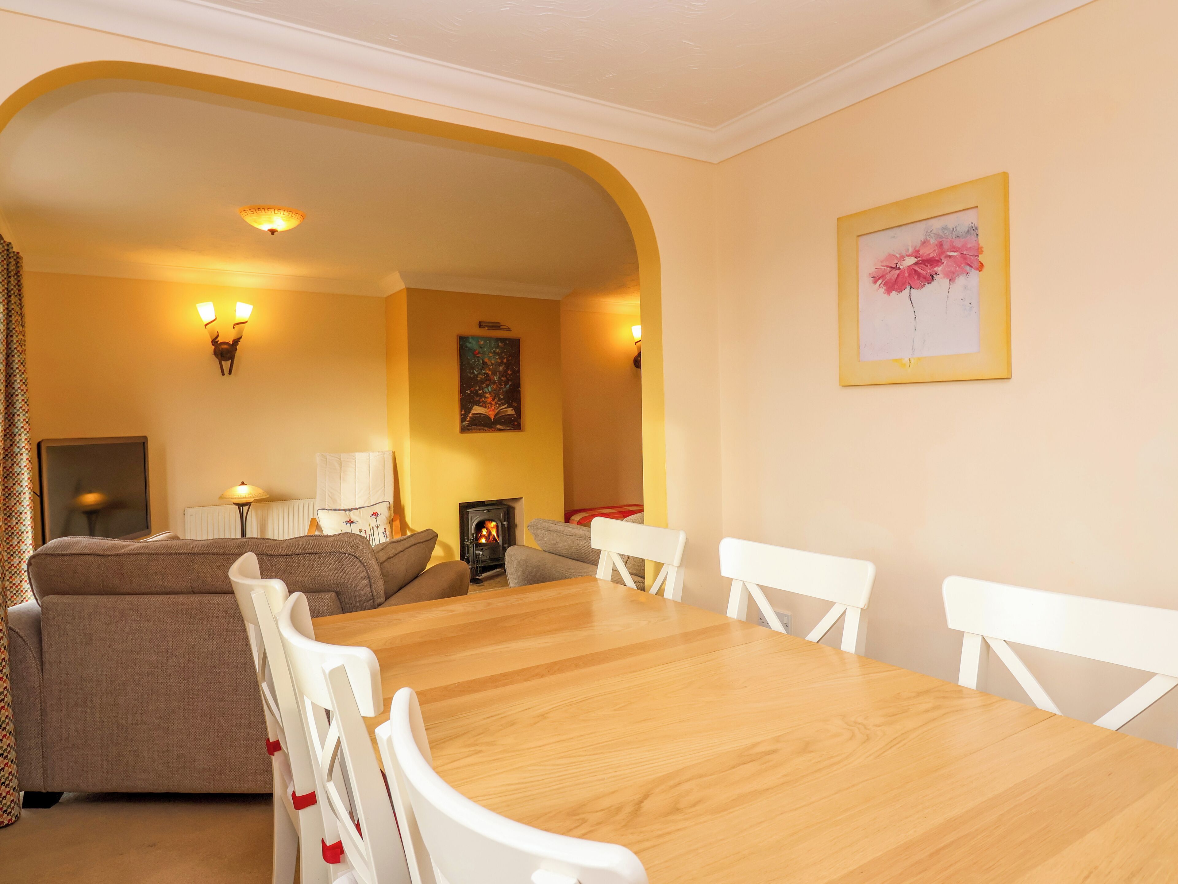Una sala de estar acogedora con chimenea, una mesa de comedor con sillas y un sofá.