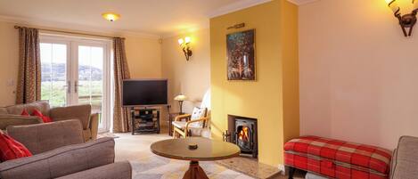 A living room with a fireplace, a television, and a sofa.