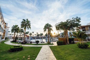 A resort with a pool area, palm trees, and a pathway leading to the pool. - SUNRISE Remal Resort - All Inclusive (Sharm El Sheikh)