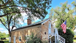 A brick building with a white staircase and an American flag. - Cottage on quiet farm close to town and wineries  (Charlottesville)